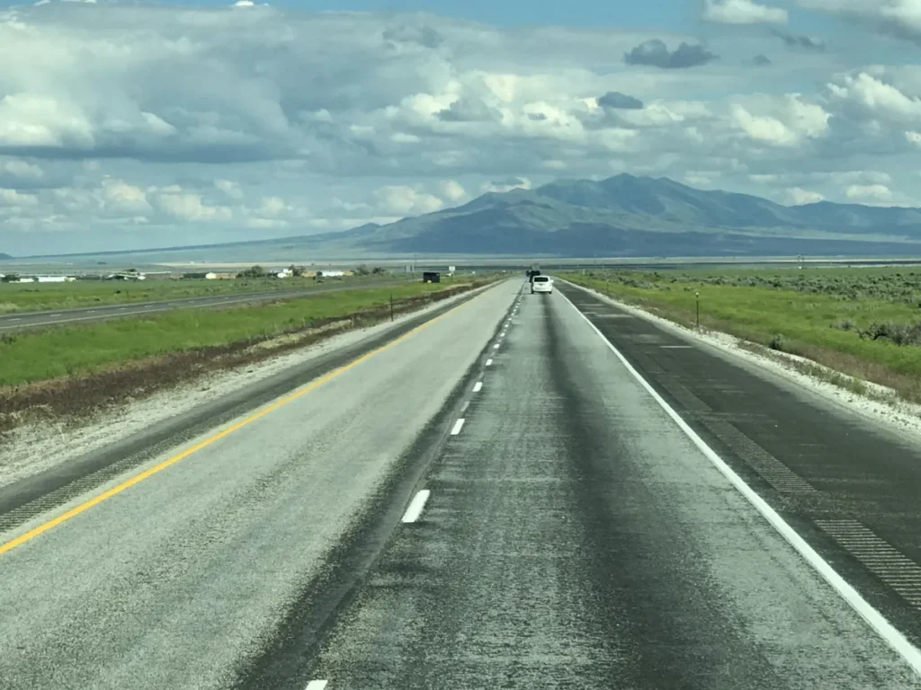 Open interstate highway through high-desert country under a cloudy sky